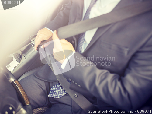 Image of senior businessman fastening car seat belt