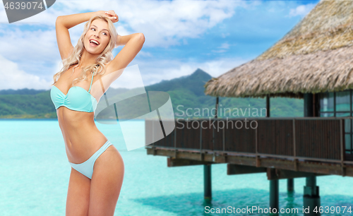 Image of young woman posing in bikini on beach