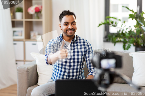 Image of male blogger with camera videoblogging at home