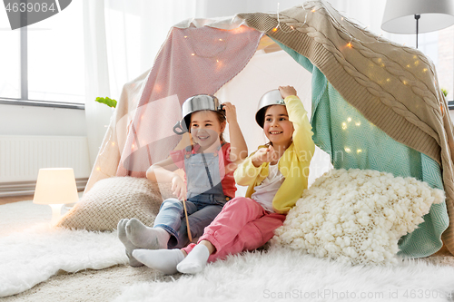 Image of girls with pots playing in kids tent at home