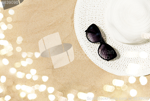 Image of straw hat and sunglasses on beach sand