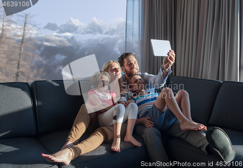 Image of happy young couple spending time with kids at home