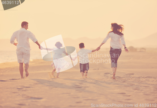 Image of happy young family have fun on beach at sunset