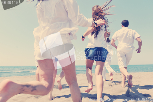 Image of happy people group have fun and running on beach