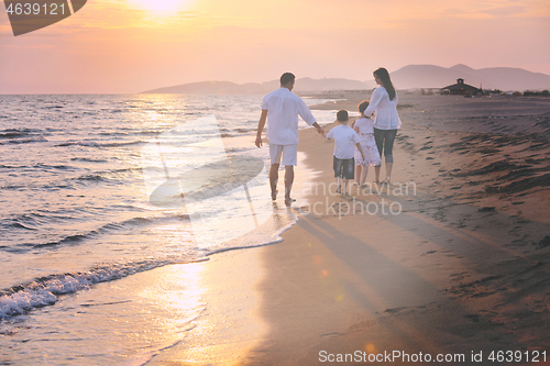 Image of happy young family have fun on beach at sunset