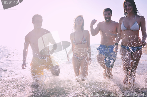 Image of happy people group have fun and running on beach