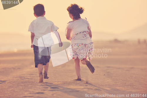 Image of happy young family have fun on beach at sunset