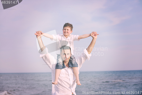 Image of happy father and son have fun and enjoy time on beach