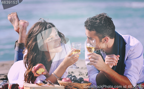 Image of young couple enjoying  picnic on the beach