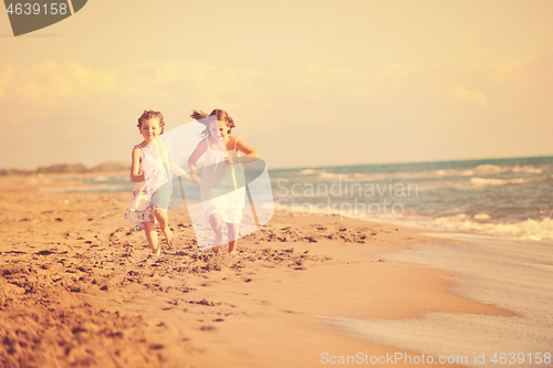 Image of cute little girls running on beach