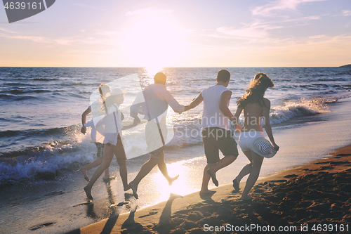 Image of people group running on the beach