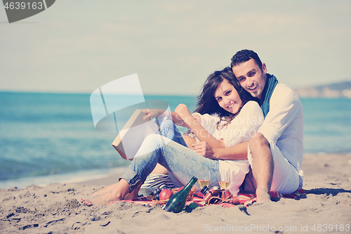 Image of young couple enjoying  picnic on the beach