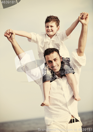 Image of happy father and son have fun and enjoy time on beach