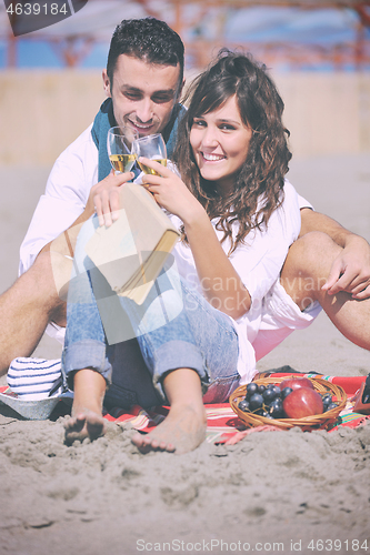 Image of young couple enjoying  picnic on the beach