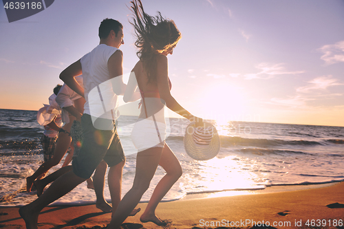 Image of people group running on the beach