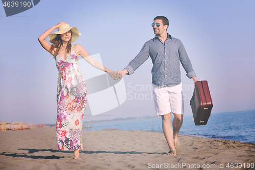 Image of couple on beach with travel bag