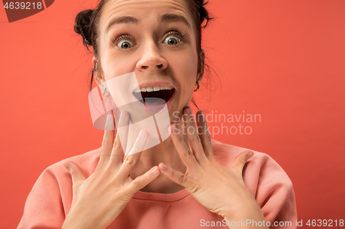 Image of Beautiful woman looking suprised isolated on coral