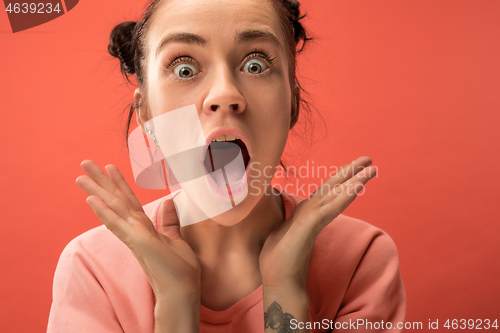 Image of Beautiful woman looking suprised isolated on coral