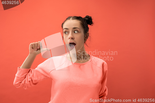 Image of Beautiful woman looking suprised isolated on coral