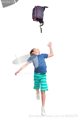 Image of Full length portrait of cute little kid in stylish clothes jumping with bag