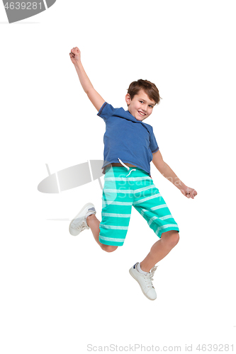 Image of Adorable boy jumping and raises his hands up.