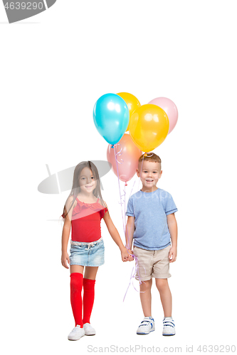 Image of Full length portrait of cute little kids in stylish clothes looking at camera and smiling