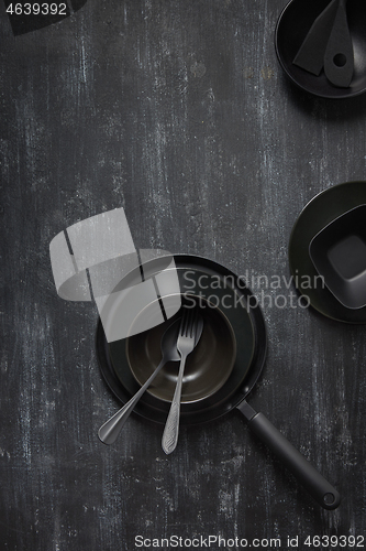 Image of Dinner served table with black cookware on the same color background.