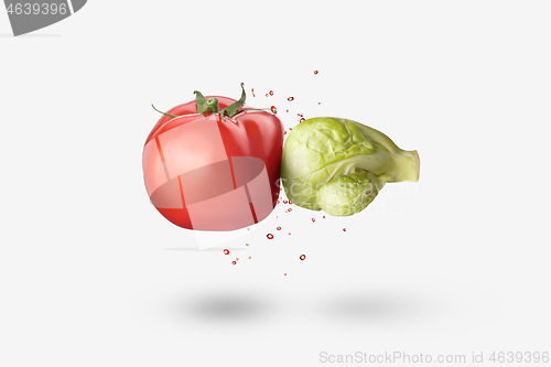 Image of Organic cabbage as a boxing glove is hitting red tomato vegetable.