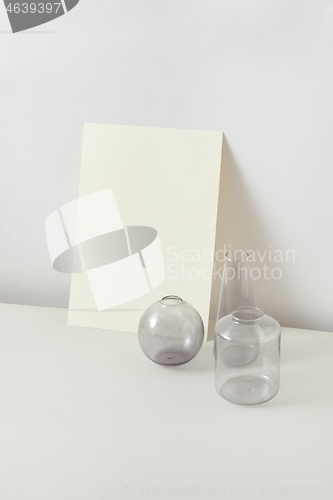 Image of Empty glass vases and natural craft paper sheet card for text.