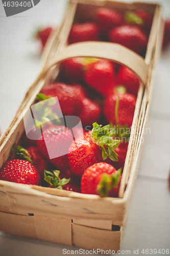 Image of Fresh healthy strawberries in a wooden box on white background.