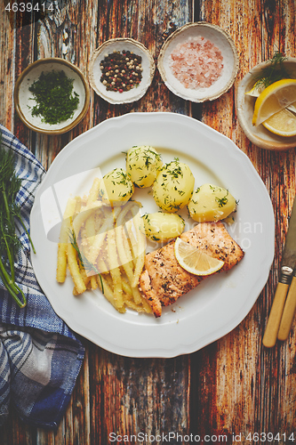 Image of Fresh and tasty baked salmon served with young boiled potatoes and yellow bean.