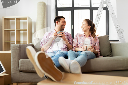 Image of happy couple drinking coffee moving to new home