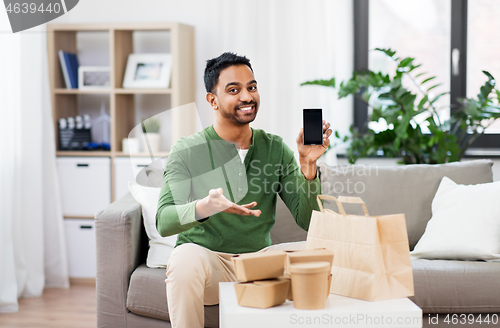 Image of indian man using smartphone for food delivery