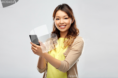 Image of happy asian woman using smartphone