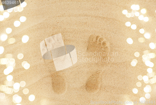 Image of footprints in sand on summer beach