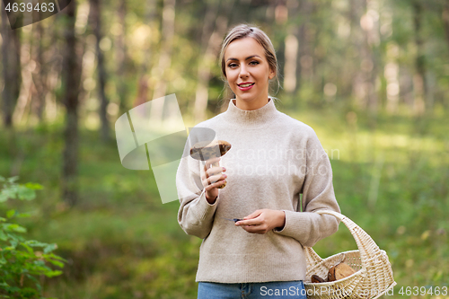 Image of young woman with mushroom in autumn forest