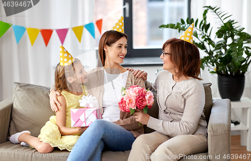 Image of daughter with gift box greeting mother on birthday