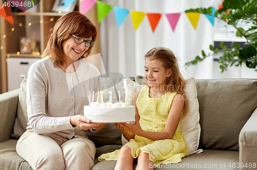 Image of grandmother and granddaughter with birthday cake