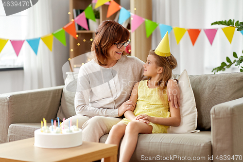 Image of grandmother and granddaughter with birthday cake