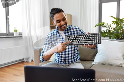 Image of male blogger with keyboard videoblogging at home