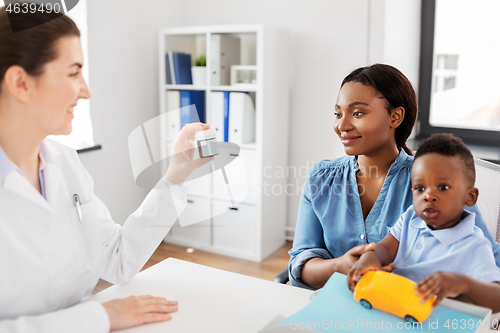 Image of doctor giving medicine to woman with son at clinic