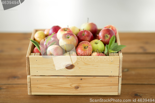 Image of ripe apples in wooden box on table