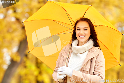 Image of happy woman with umbrella in autumn park