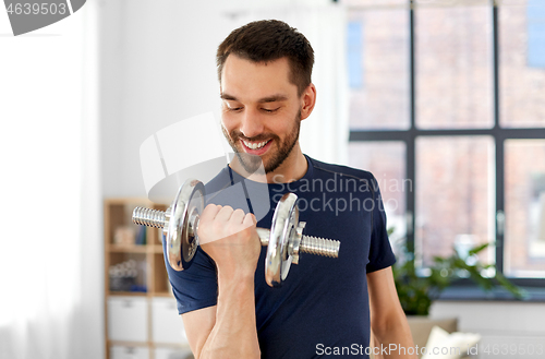 Image of man exercising with dumbbell at home