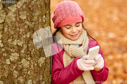 Image of girl with smartphone at autumn park