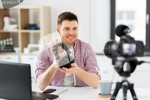 Image of male blogger with headphones videoblogging at home