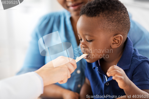 Image of doctor examining african baby\'s mouth at clinic