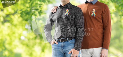 Image of close up of couple with gay pride rainbow ribbons