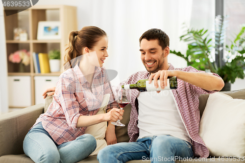 Image of happy couple drinking red wine at home