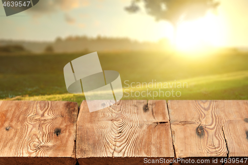 Image of Rough wooden table on natutal rural sunset landscape a for display and montage your products.